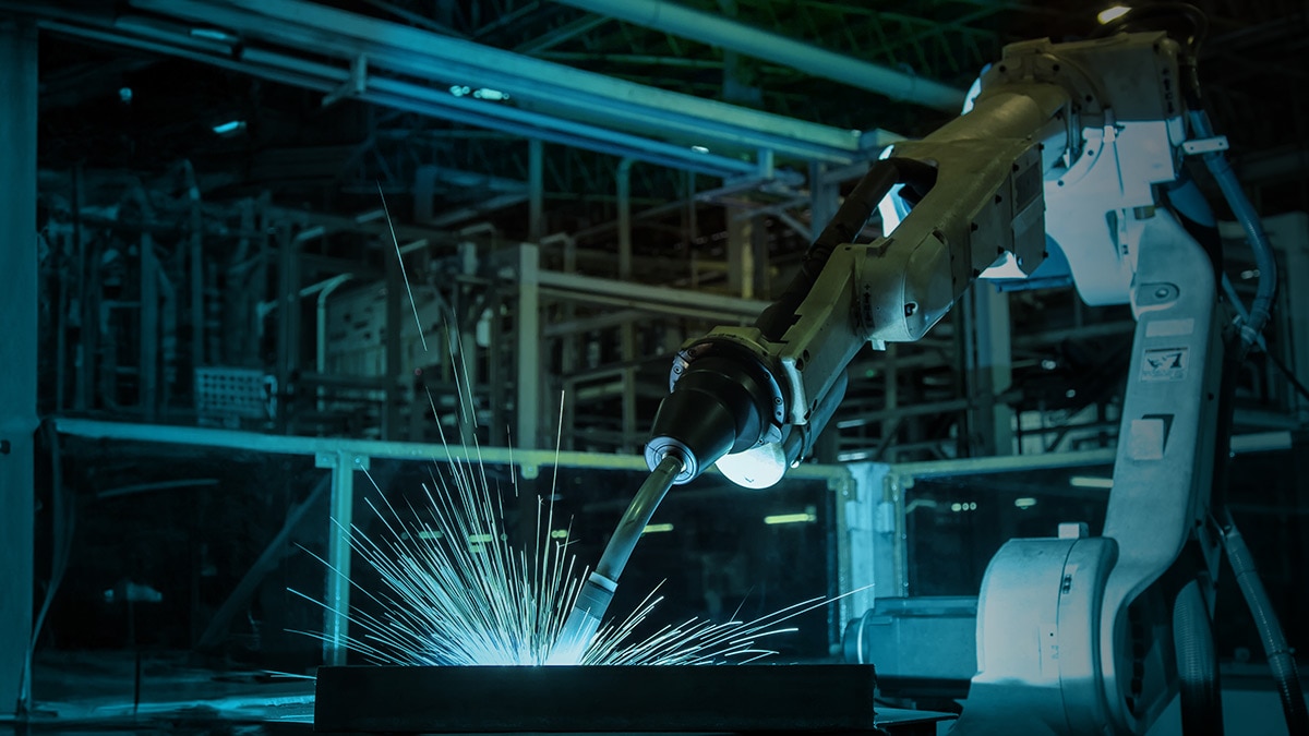 Robotic arm welding in a factory Robotic arm welding in a factory